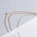 Three layered gold necklace stack